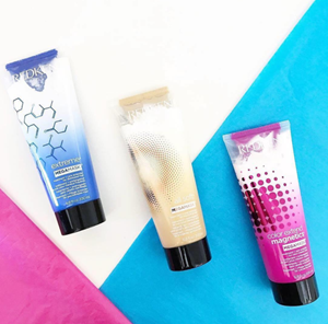 Redken Extreme, All Soft and Color Extend Magnetics Mega Masks lined up on colorful pink and blue background. 
